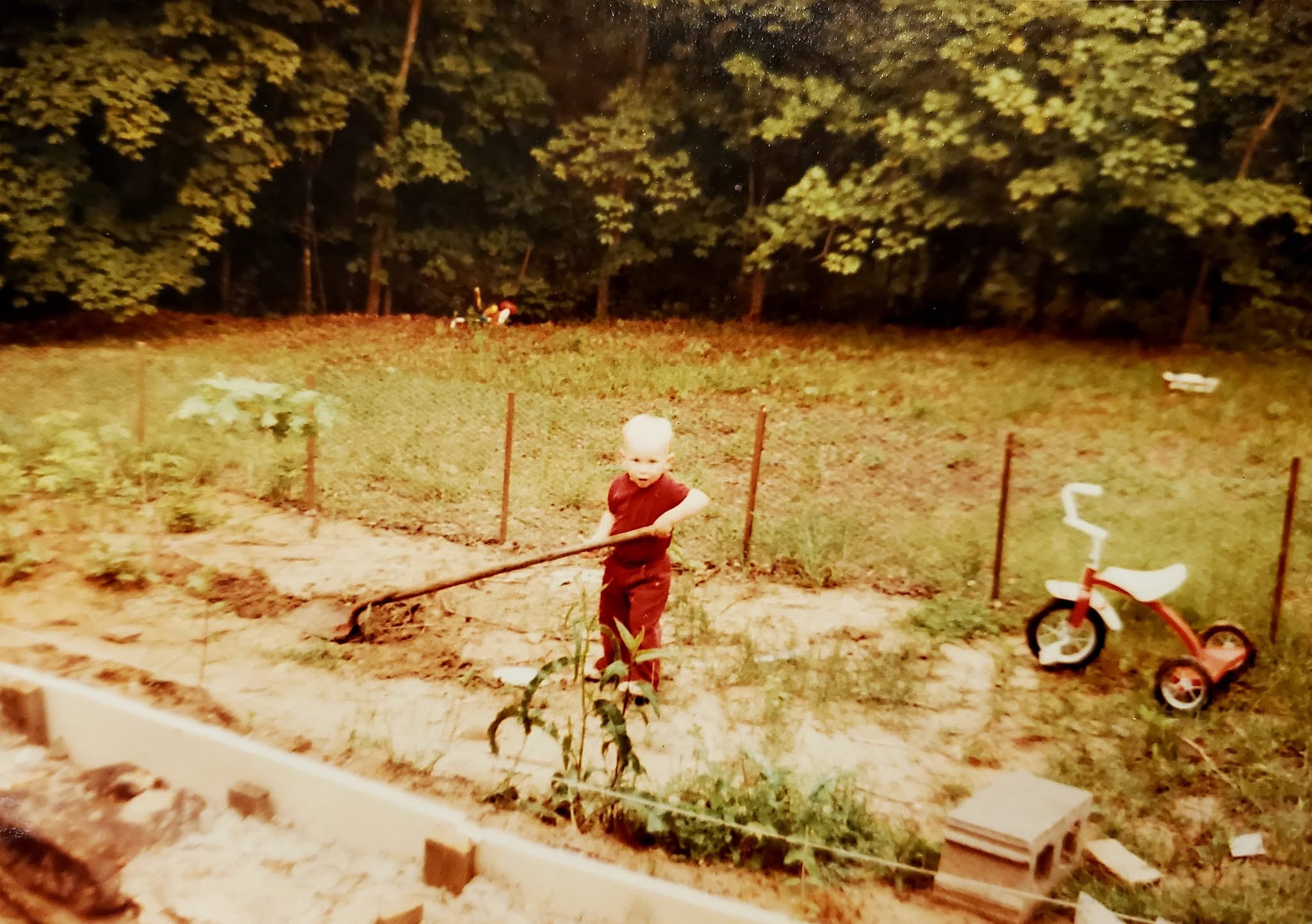 Tao Lundolos as a toddler helping in the family garden in 1982